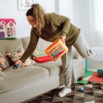 a person holding a box and a child on a couch