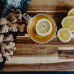 a cup of tea with lemon and ginger on a wooden table