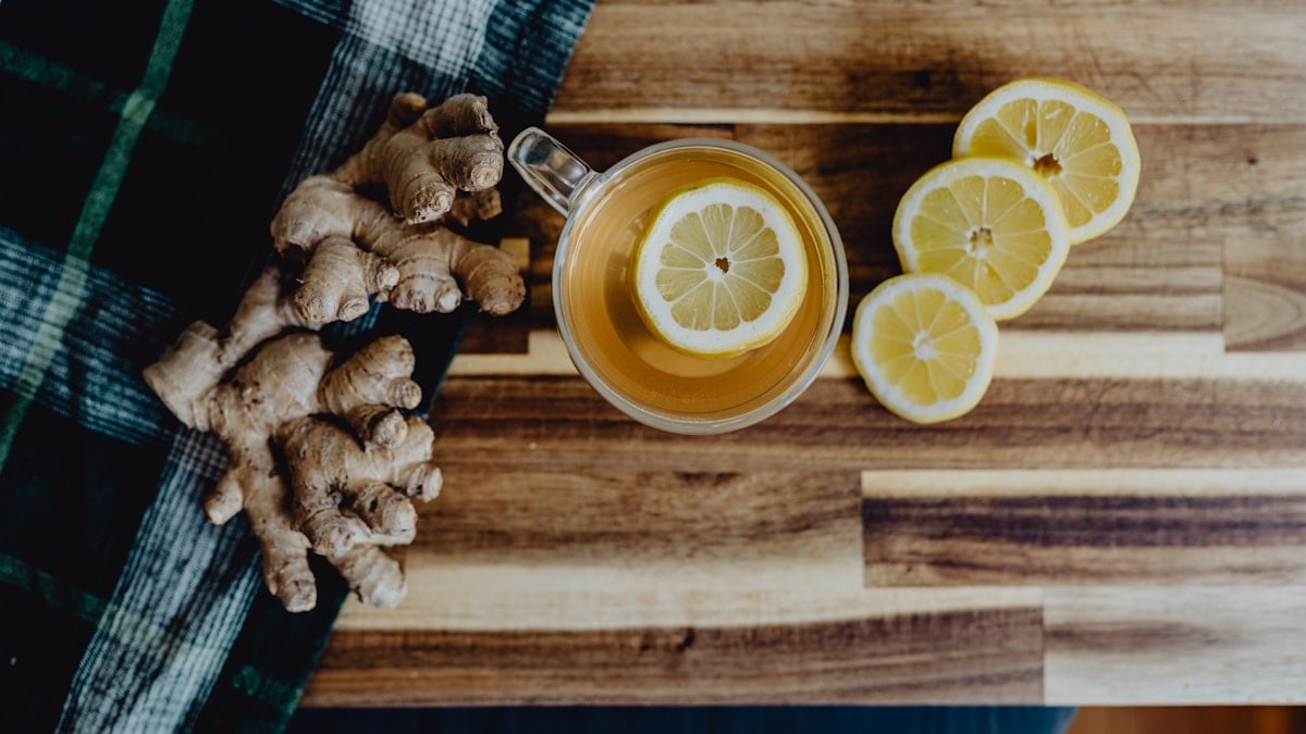 a cup of tea with lemon and ginger on a wooden table